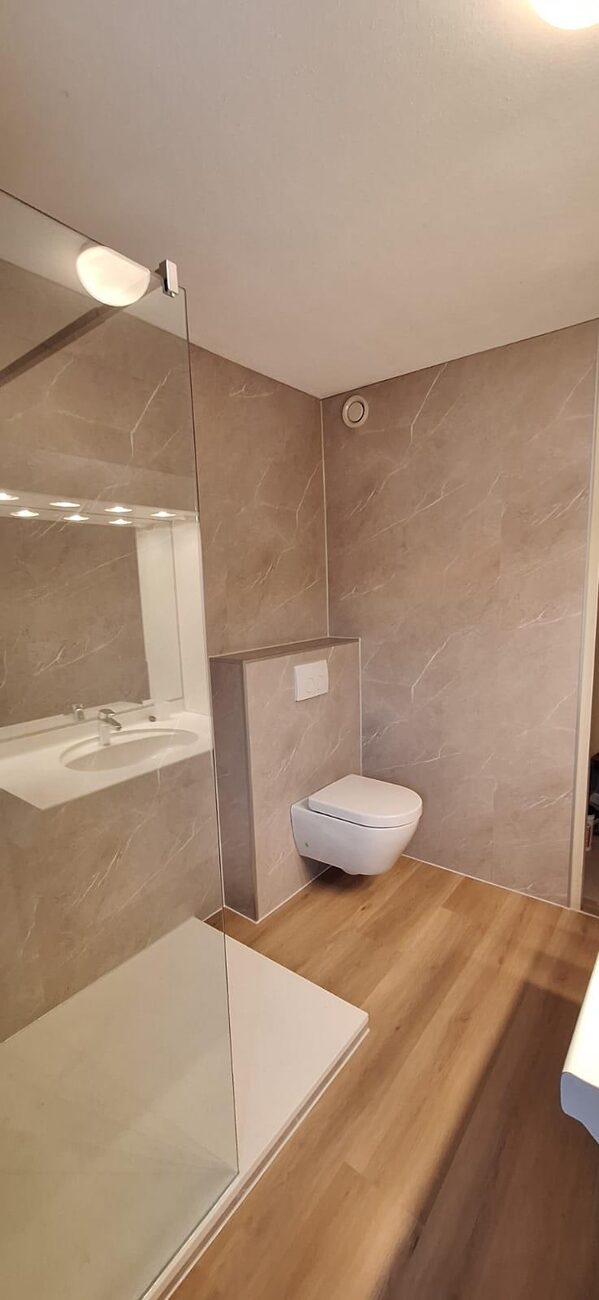 Moderne badkamer met inloopdouche, hangtoilet en houtlook vloer