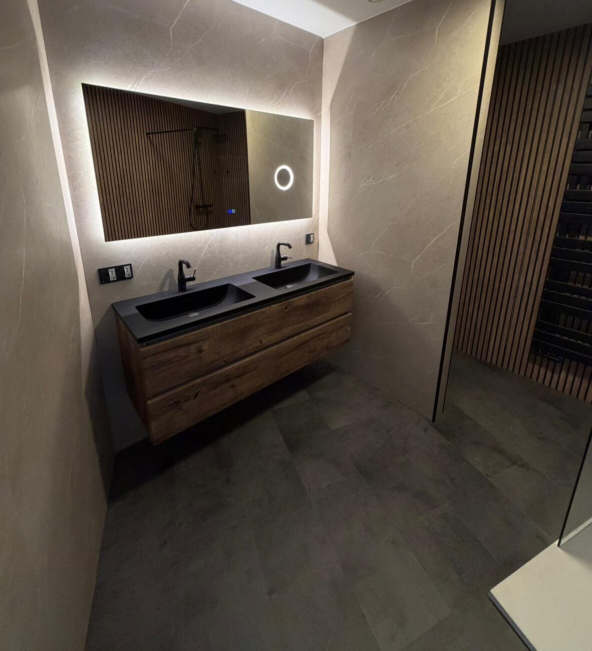 Moderne badkamer met houten wastafelmeubel en verlichte spiegel