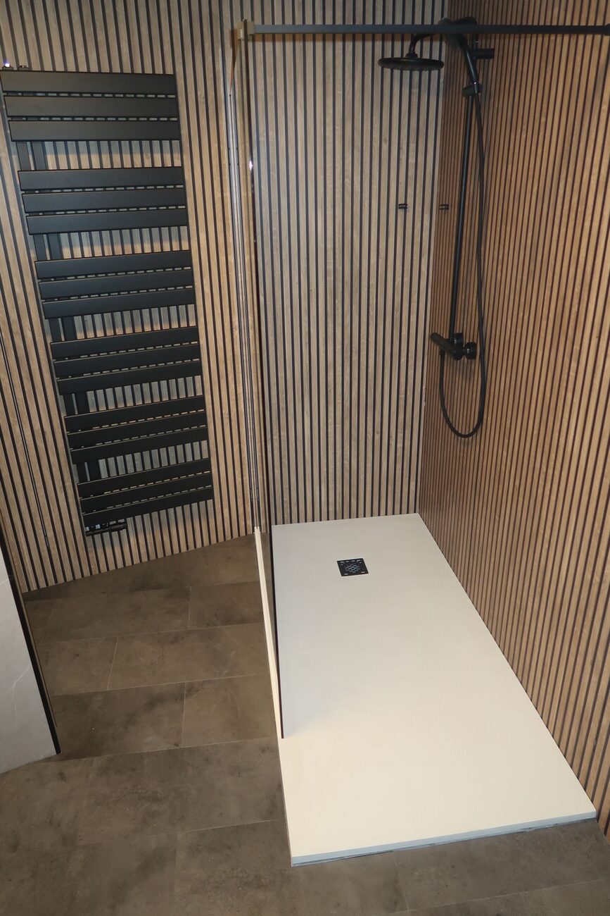 Moderne badkamer met houten lattenwand, inloopdouche en donkere vloertegels