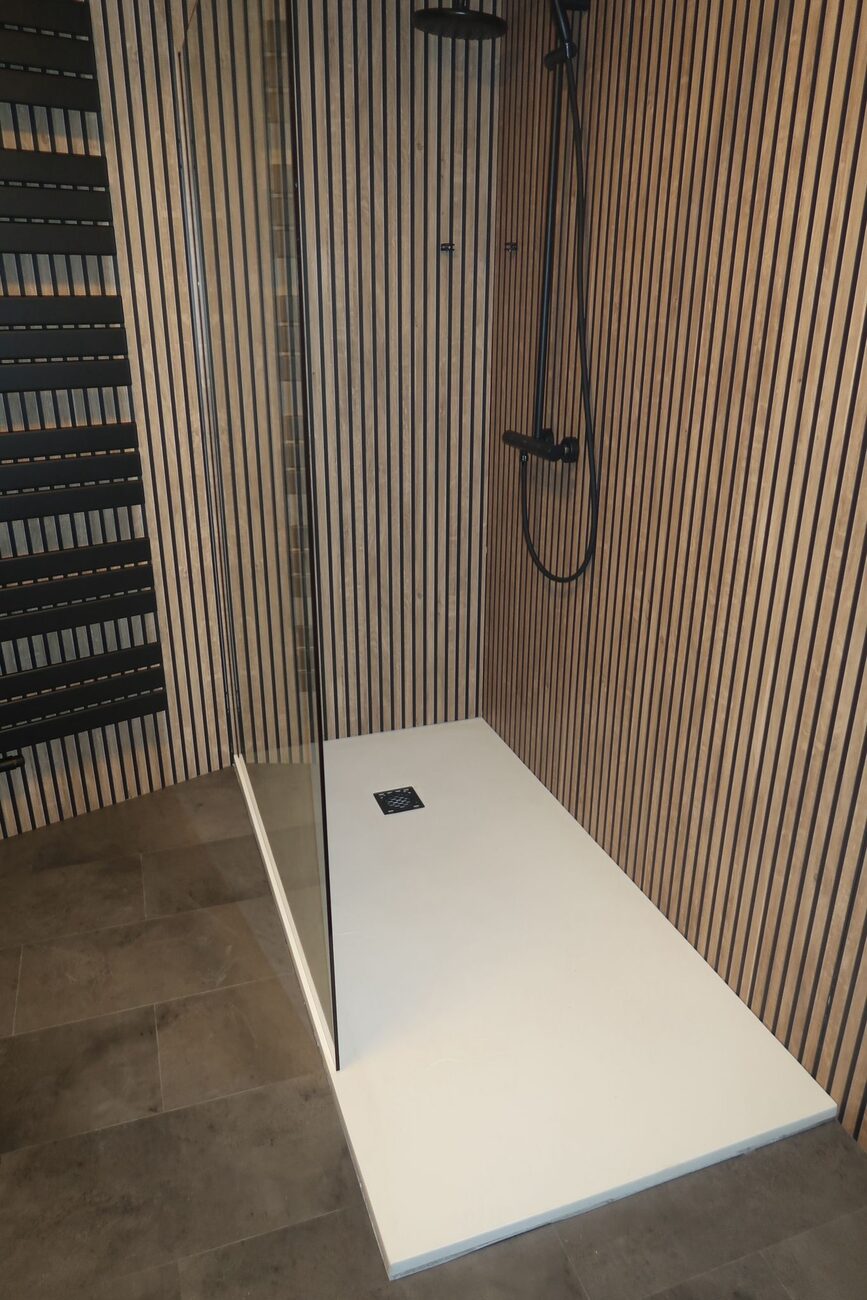 Moderne badkamer met inloopdouche, houten lattenwand en donkere vloertegels