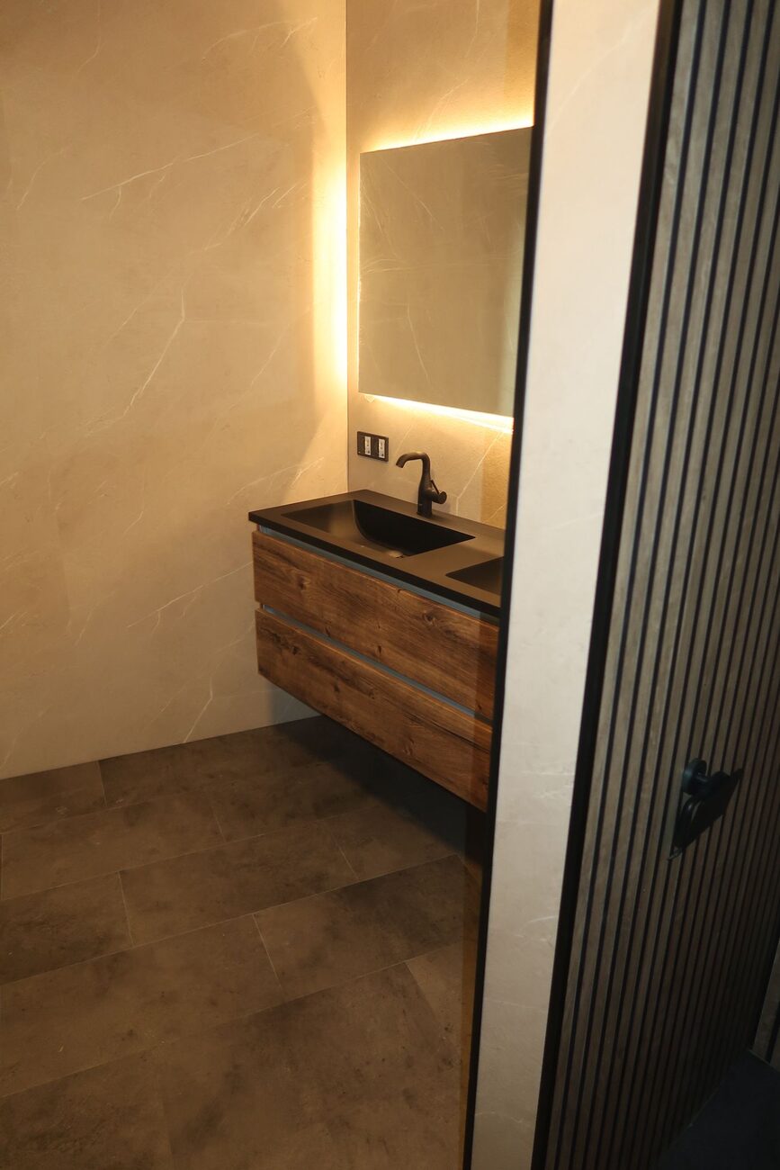 Moderne badkamer met houten wastafelmeubel en verlichte spiegel