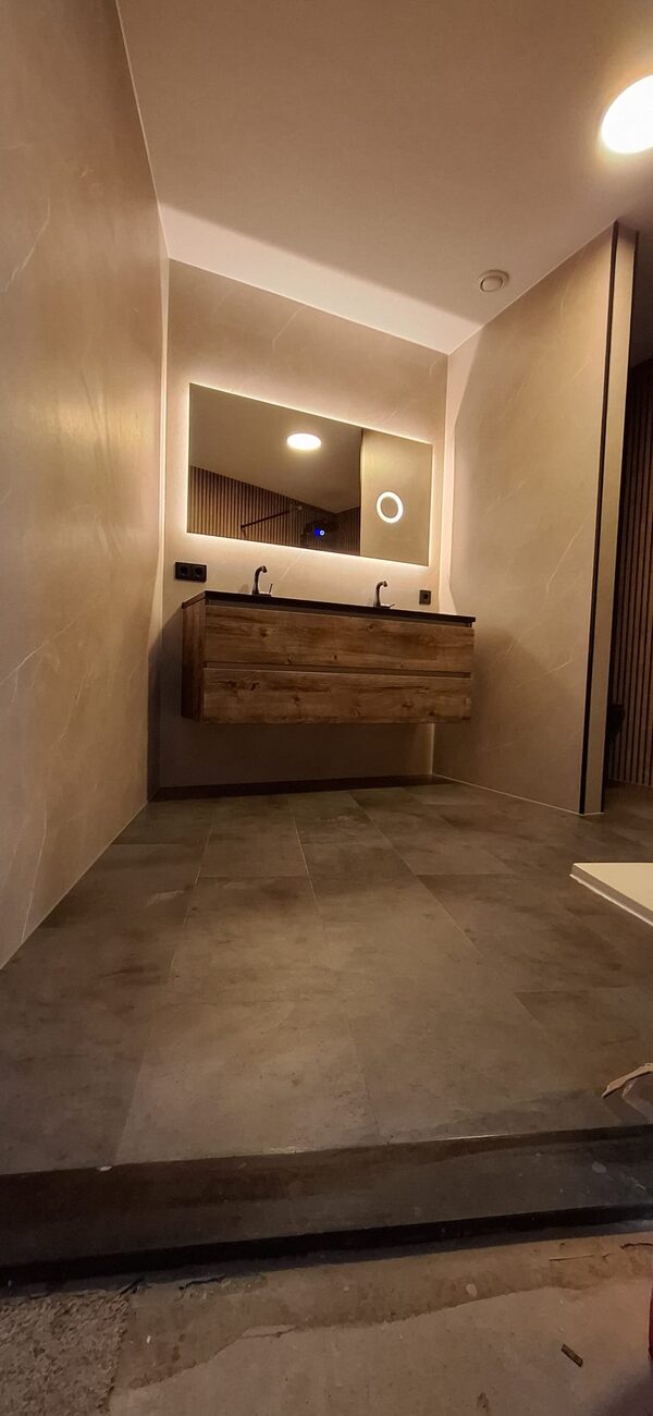 Moderne badkamer met houten wastafelmeubel en verlichte spiegel