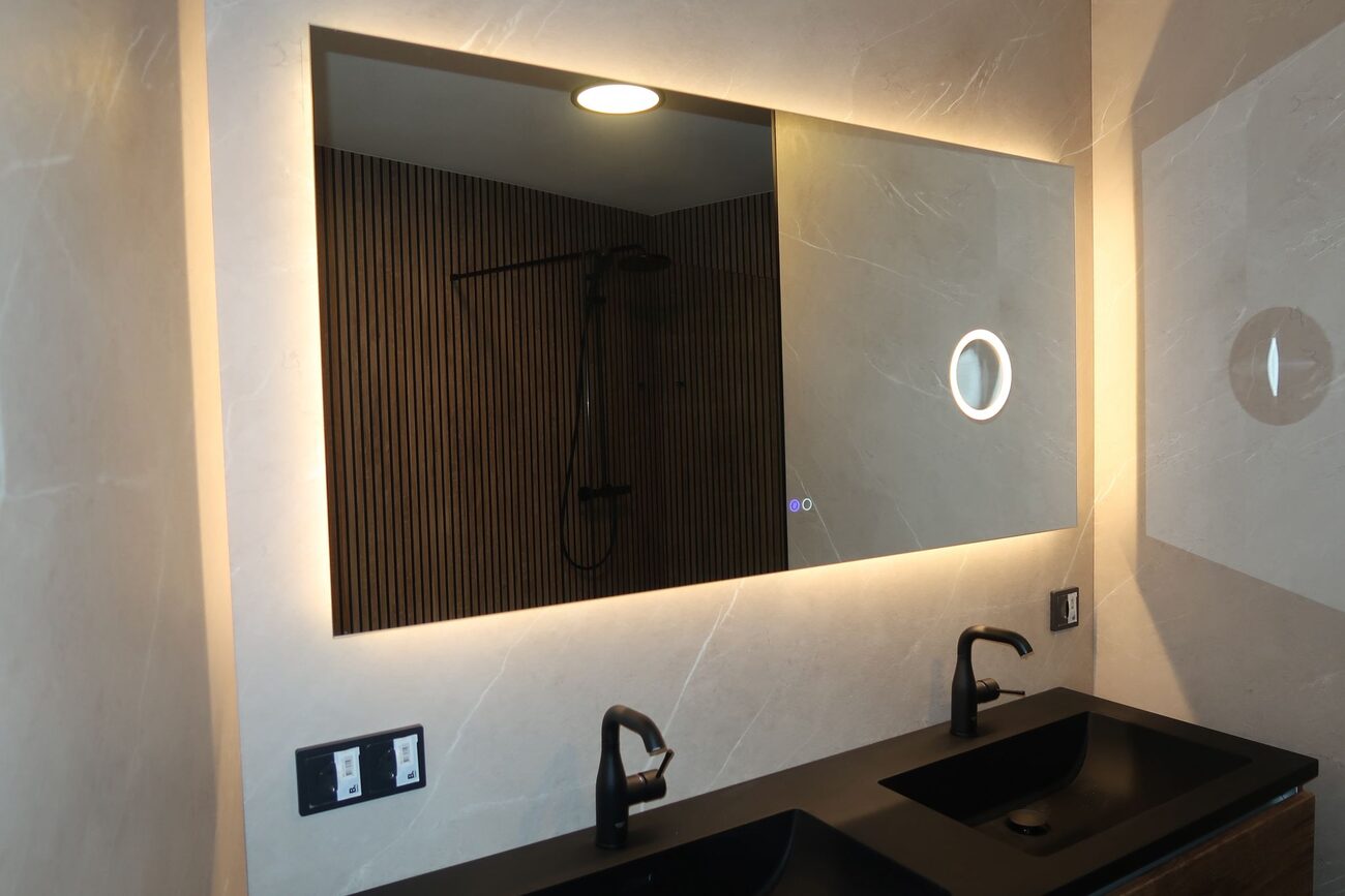 Moderne badkamer met dubbele wastafel en verlichte spiegel